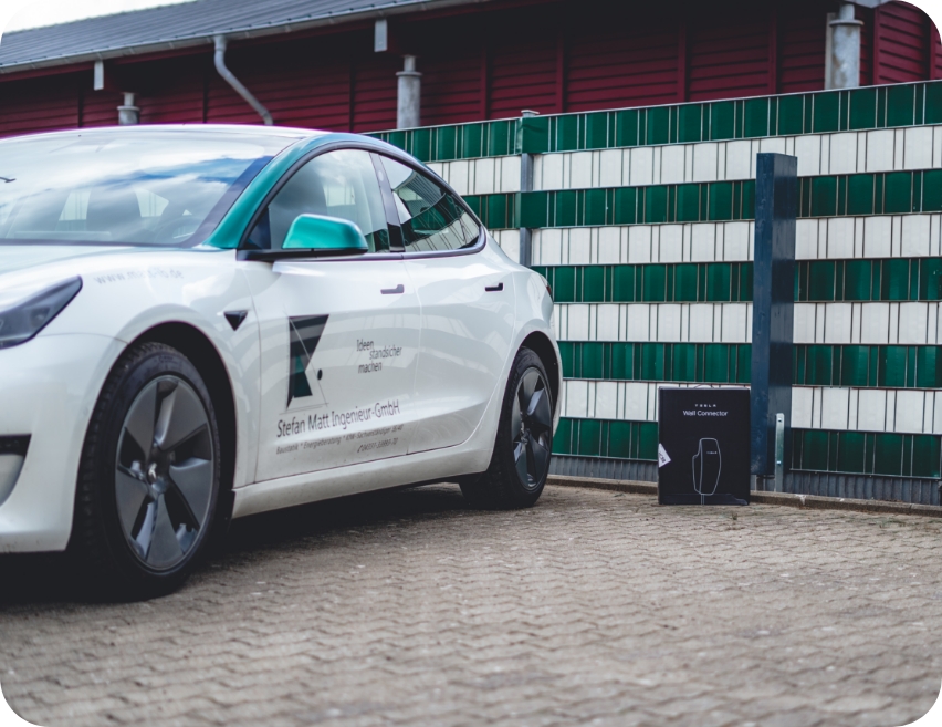 Tesla als Firmenwagen vor einer Wallbox, Angebot für neue Mitarbeiter bei Ingenieurbüro Stefan Matt