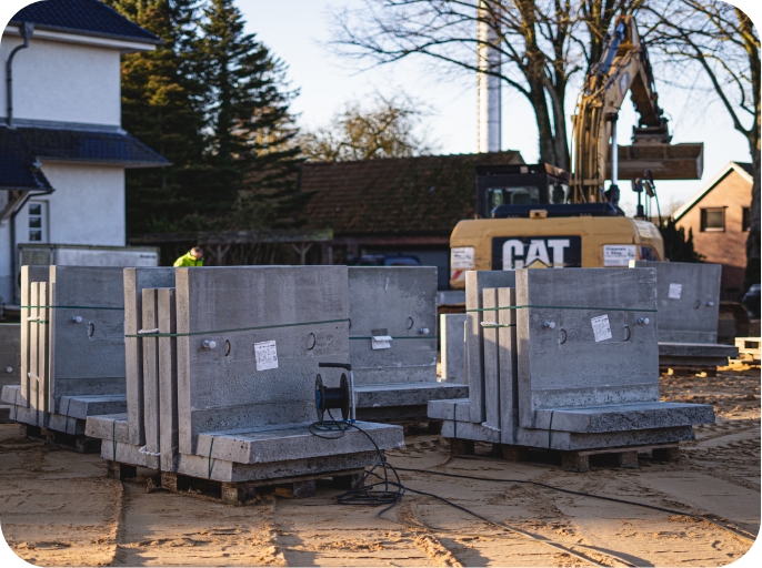 Bild einer Baustelle, das gesetzliche Bestimmungen darstellt, mit Winkelstützwänden und einem Bagger im Hintergrund